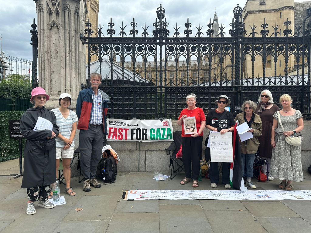 Group of activists holding a banner and signs during the FAST FOR GAZA event outside Parliament.